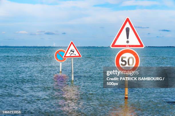 close-up of warning sign on sea against sky,france - sécurité routière photos et images de collection