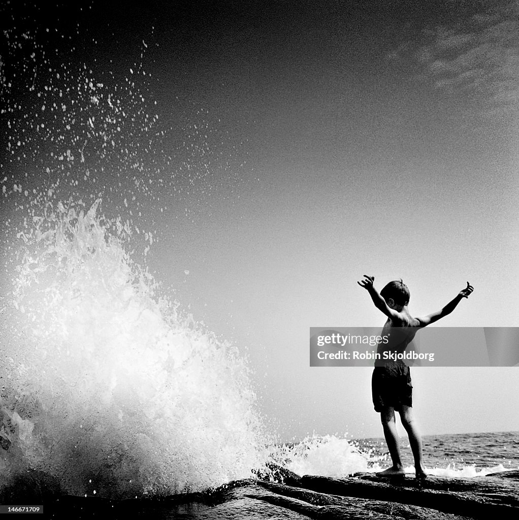 Boy in front of wave.