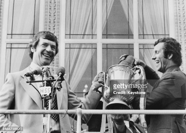 Southampton Football Club team manager Lawrie McMenemy and striker Peter Osgood hold the Football Association trophy from the balcony of Southampton...