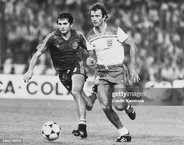 England striker Trevor Francis in motion dribbling the football past Spanish defender Rafael Gordillo during their Group B match of the 1982 FIFA...