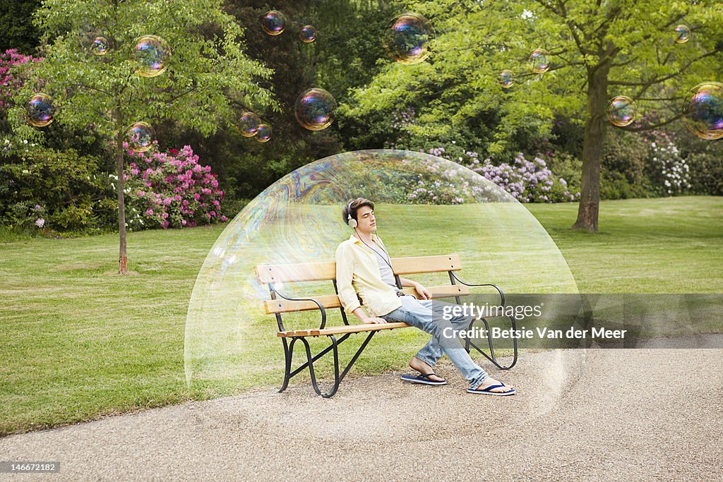 Man listening to music sitting in bubble.