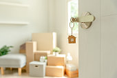 Moving house, relocation. The key was inserted into the door of the new house, inside the room was a cardboard box containing personal belongings and furniture. move in the apartment or condominium