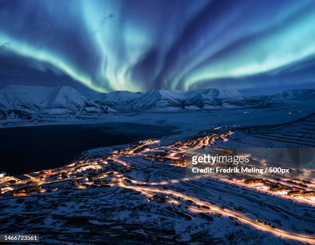 scenic view of illuminated snowcapped mountains against sky at night,longyearbyen,norway - spitsbergen stockfoto's en -beelden