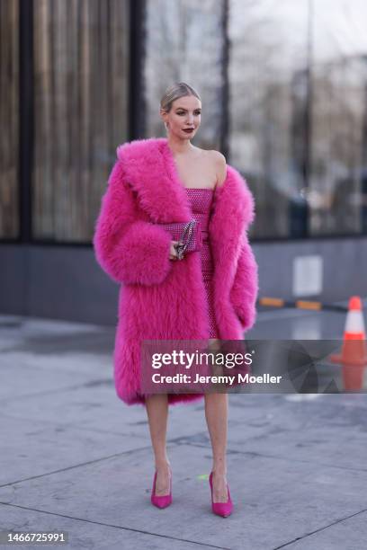 Leonie Hanne seen wearing a pink fur coat, a pink sequins dress, pink heels and a matching pink bag before the Michael Kors show on February 15, 2023...