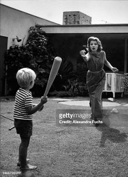 Actress Gena Rowlands plays baseball with her son Nick at their house in 1964, at Los Angeles, California.