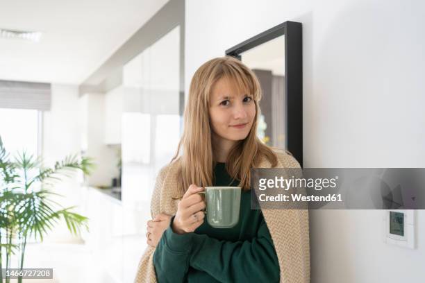 smiling woman standing with tea cup at home - hot arabic women fotografías e imágenes de stock
