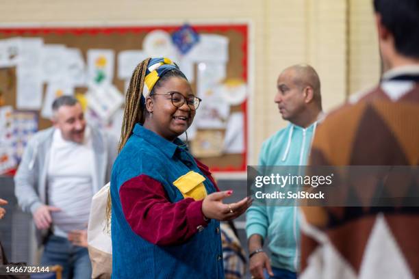 sich gegenseitig in der community-gruppe willkommen heißen - gemeindezentrum stock-fotos und bilder