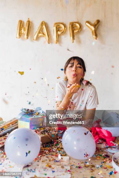 woman blowing confetti standing in front of wall - helium bildbanksfoton och bilder