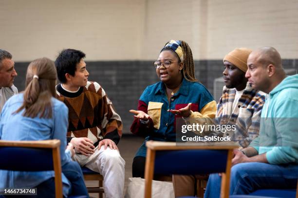 explaining to the group in community centre - diverse community 個照片及圖片檔