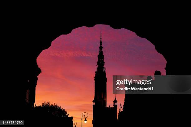 silhouette of town hall tower and arch of green gate at dusk - town hall tower stock pictures, royalty-free photos & images