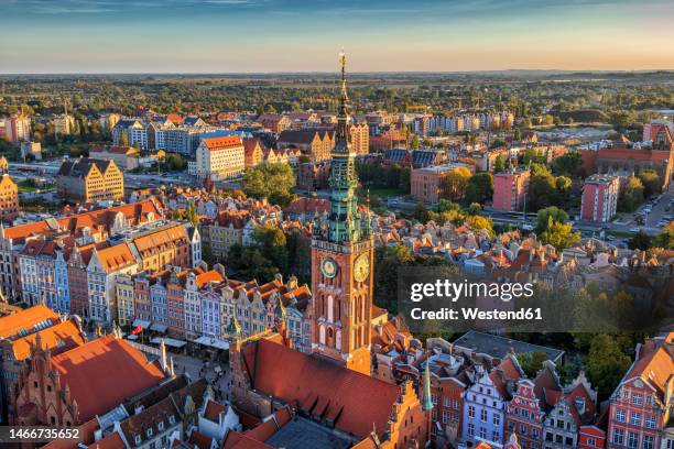 town hall tower amidst buildings in city at sunset - krakow poland stockfoto's en -beelden