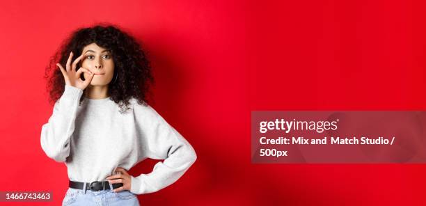 image of cute girl with curly hair making promise to stay quiet - zipper mouth stock pictures, royalty-free photos & images