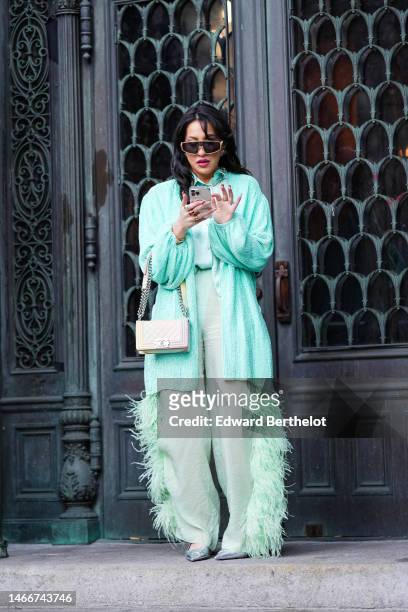 Guest wears gold sunglasses, silver earrings, a silver large chain necklace, a mint green silk shirt, gold and silver rings, a mint green braided...