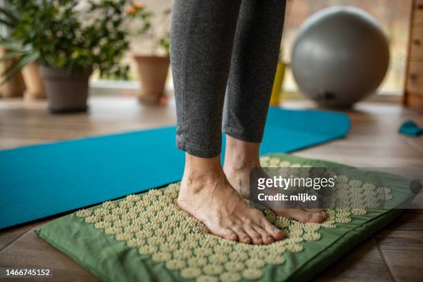 mature woman exercising against flat feet at home - pointed foot stock pictures, royalty-free photos & images