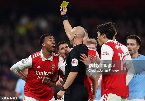 Referee Anthony Taylor awards a yellow card to Gabriel of Arsenal, before the decision is reversed following a VAR Penalty Review, during the Premier...