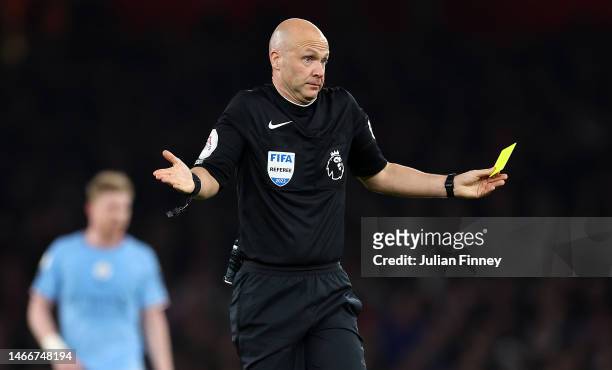 Referee Anthony Taylor awards a yellow card to Ederson for time wasting during the Premier League match between Arsenal FC and Manchester City at...