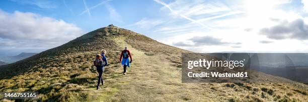 friends hiking on mountain at sunny day - outdoor pursuit stock pictures, royalty-free photos & images