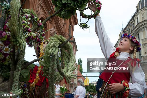 Girl sells Jani decorations on June 22, 2012 on a traditional Grass market in Riga. The market is held every year in Latvian cities to prepare for...