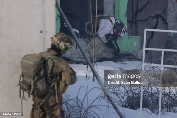 Soldier of the Bundeswehr, the German armed forces, looks towards a Slovenian soldier playing dead during military exercises of the NATO...