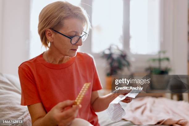 mulher lendo uma prescrição que veio com pílulas de medicamentos para terapia de reposição hormonal - hrt pill - fotografias e filmes do acervo