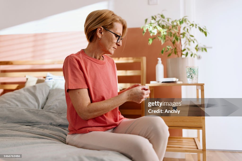 Frau bereitet sich darauf vor, ein Klebepflaster für die Hormonersatztherapie aufzutragen