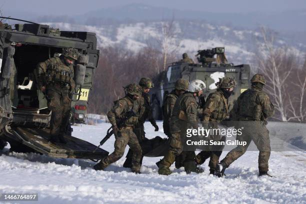 Soldiers of the Bundeswehr, the German armed forces, evacuate a wounded comrade as a simulation during military exercises of the NATO multinational...