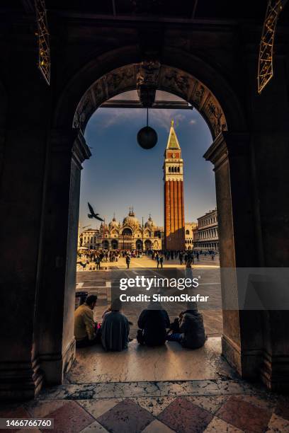 vista della basilica di san marco e del campanile visti attraverso l'arco - piazze italiane foto e immagini stock