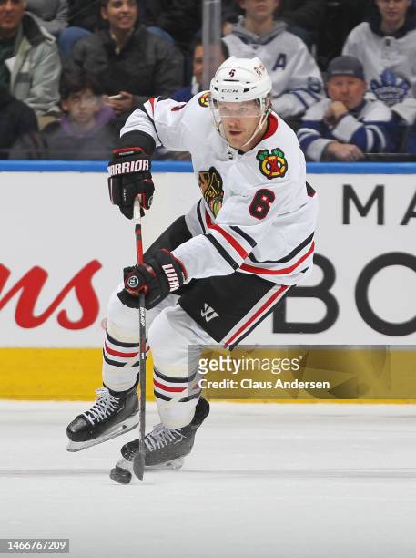 Jake McCabe of the Chicago Blackhawks skates with the puck against the Toronto Maple Leafs during an NHL game at Scotiabank Arena on February 15,...
