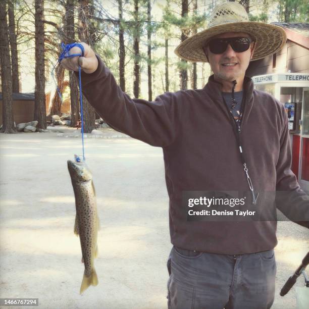 senior man with brown trout - brown trout stock pictures, royalty-free photos & images