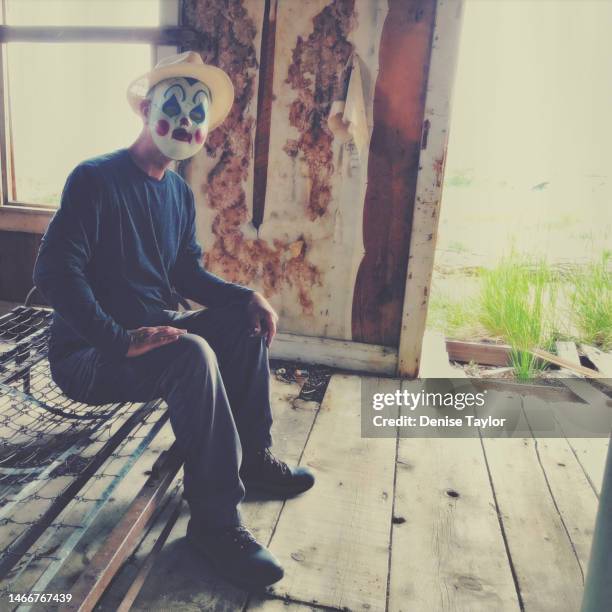 man wearing clown mask in old house - evil clown stock pictures, royalty-free photos & images