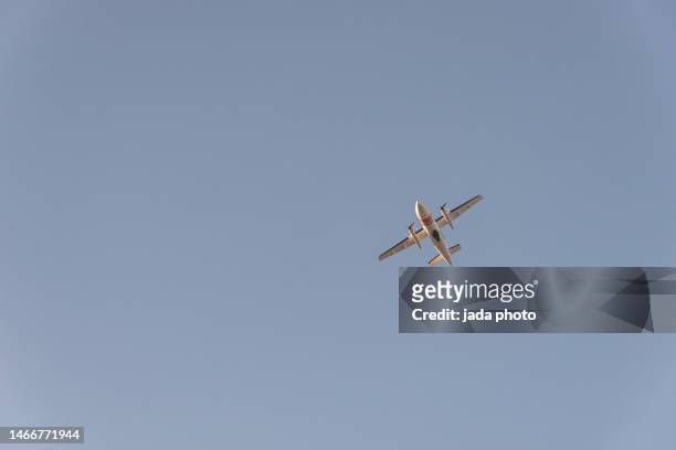reconnaissance plane with camera under the fuselage flying in the sky - propeller plane stock-fotos und bilder
