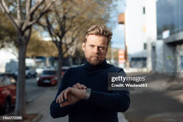 man wearing wristwatch on footpath - watch time stock pictures, royalty-free photos & images