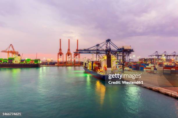 container ships at illuminated dock - mar rosso foto e immagini stock