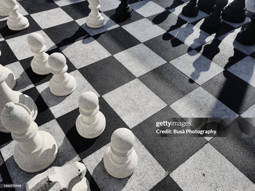 Giant chess game on checkered blocks in public park