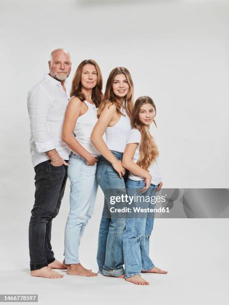 family standing in line against white background - familie mit zwei generationen stock-fotos und bilder