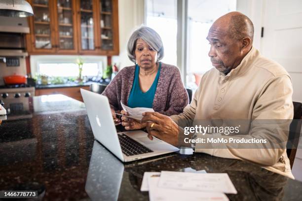 senior couple paying bills with laptop at home - invoice stock pictures, royalty-free photos & images