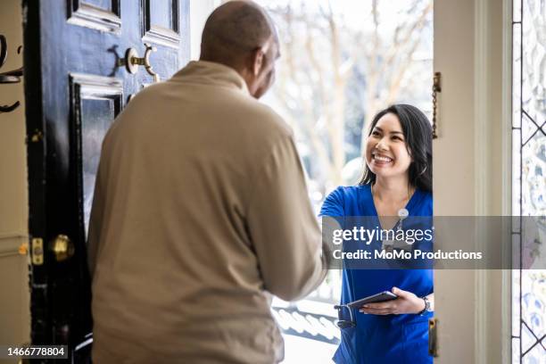 senior man greeting home nurse at front door of home - the women of netflixs one day at a time for your consideration event arrivals stockfoto's en -beelden