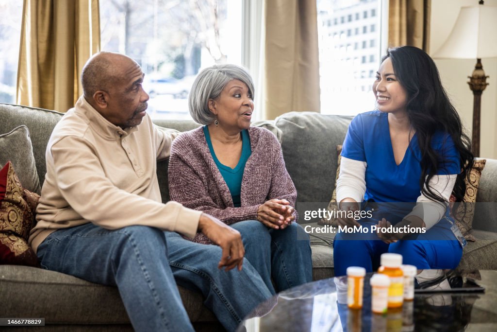 Senior couple talking about medications with home nurse