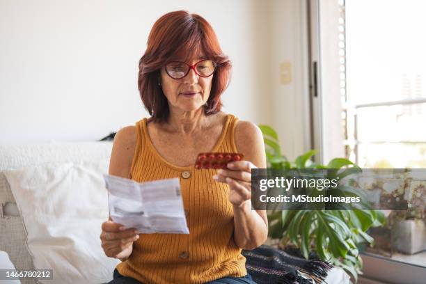latin woman checking patient information leaflet for her medicine. - hormone therapy stock pictures, royalty-free photos & images