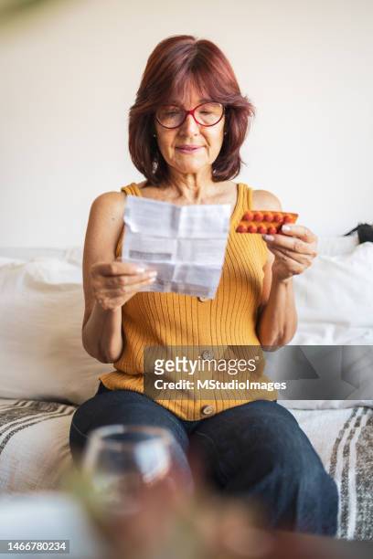 latin woman checking patient information leaflet for her medicine. - transdermal stock pictures, royalty-free photos & images