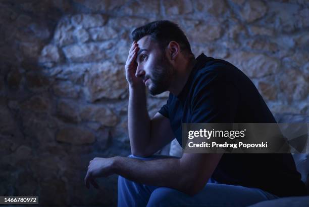 worried  man sitting on sofa - pessimism stock pictures, royalty-free photos & images