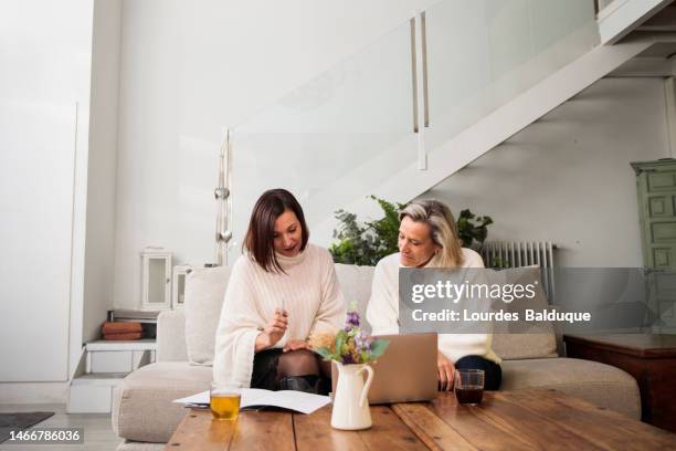 real estate agent showing brochure to female client at her home - authentic real stockfoto's en -beelden