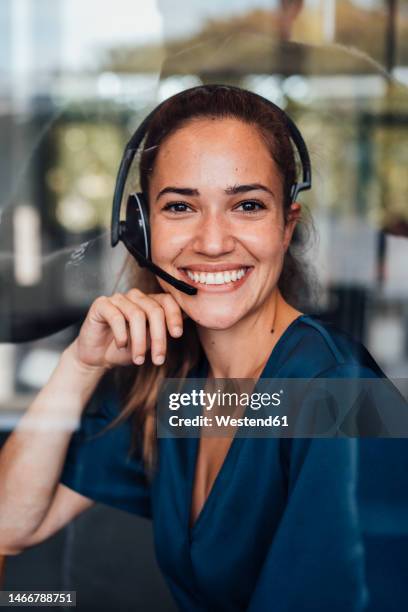 happy businesswoman wearing headset sitting in soundproof cabin - soundproof stock pictures, royalty-free photos & images