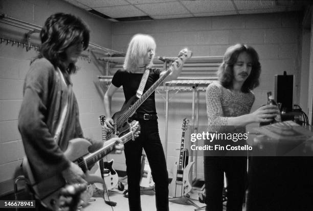 Joe Perry, Tom Hamilton and guitarist Brad Whitford from Aerosmith tune up backstage before their concert at Madison Square Garden in New York on...