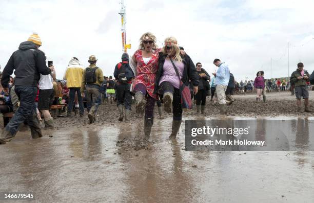 Festival-goers splash around in the mud during the Isle of Wight Festival 2012 at Seaclose Park on June 22, 2012 in Newport, United Kingdom.