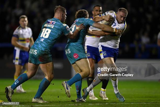 James Harrison of Warrington is tackled by Tom Holroyd and Cameron Smith of Leeds during the Betfred Super League between Warrington Wolves and Leeds...
