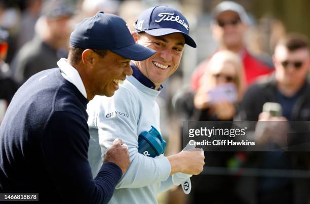Tiger Woods of the United States and Justin Thomas of the United States walk across the ninth hole during the first round of the The Genesis...