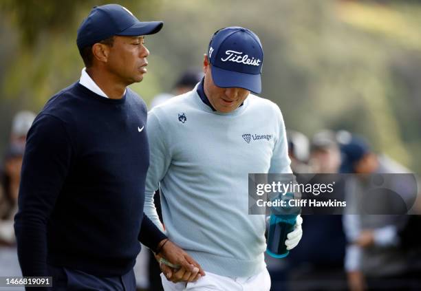 Tiger Woods of the United States and Justin Thomas of the United States walk off the ninth tee during the first round of the The Genesis Invitational...