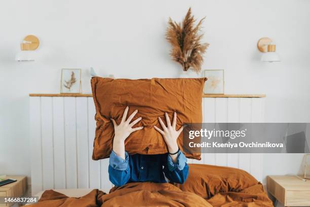 top view depressed woman covering face with pillow, lying on bed at home alone, frustrated unhappy young female suffering from insomnia, mental or relationship problems, break up or divorce - woman pillow stock pictures, royalty-free photos & images