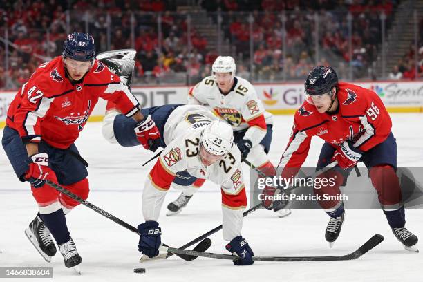 Carter Verhaeghe of the Florida Panthers is checked by Martin Fehervary of the Washington Capitals during the first period at Capital One Arena on...